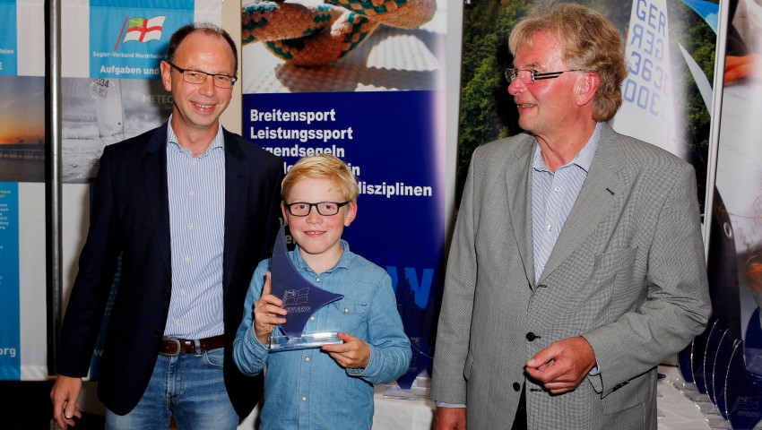 Kai Wodicke (SVNRW) und Manfred Lenz (SVNRW)  gratulieren Jannik Julius Rausch (Meister Opti-B)